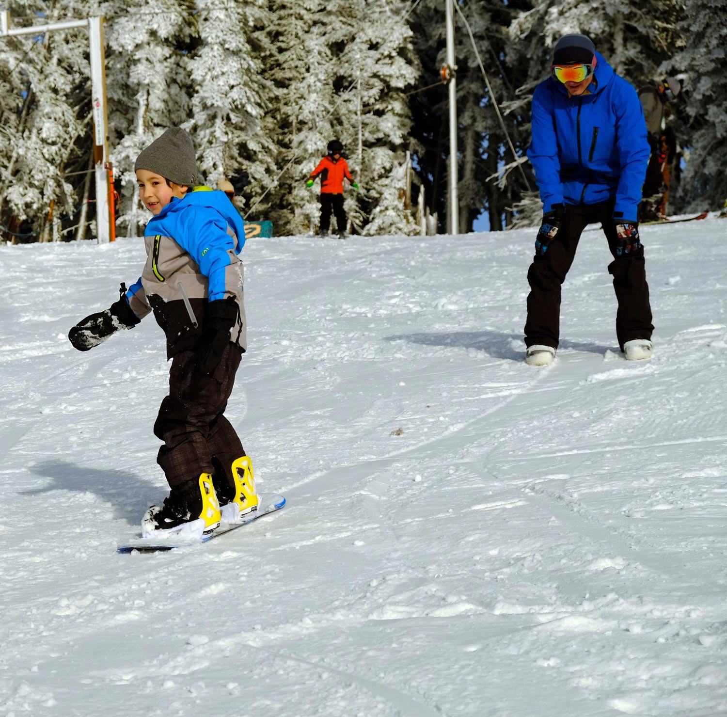 A young snowboarder rides toward an instructor in the snow at Hurricane Ridge.